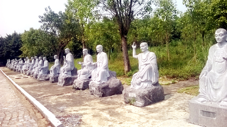 Những bức tượng Phật bằng đá xanh dọc con đường dẫn xuống chân núi.