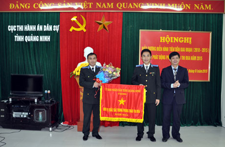 Đồng chí Lê Quang Tùng, Phó Chủ tịch UBND tỉnh trao cờ dẫn đầu phong trào thi đua công tác thi hành án năm 2014 của UBND tỉnh cho Cục Thi hành án dân sự TP Cẩm Phả