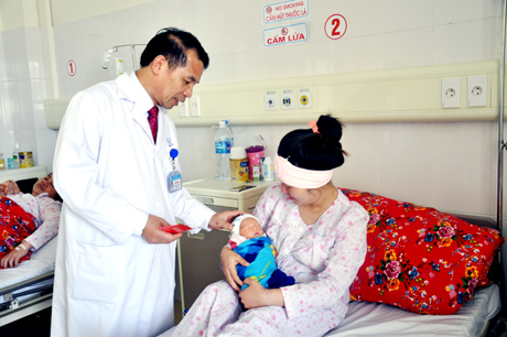 Bác sĩ Đỗ Văn Thinh, Trưởng Khoa Sản thăm, mừng tuổi cho bé Đoàn Gia Bảo - cháu bé đầu tiên ra đời trong năm Ất Mùi tại Bệnh viện Sản - Nhi tỉnh.