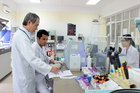 Tiến sĩ, Thầy thuốc Ưu tú Nguyễn Quang Trung (ngoài cùng, bên trái) hướng dẫn nhân viên làm việc tại Phòng thí nghiệm.