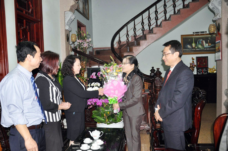Đồng chí Phó Chủ tịch UBND tỉnh Vũ Thị Thu Thủy tặng hoa chúc mừng Thầy thuốc Nhân dân Nguyễn Thị Tân.