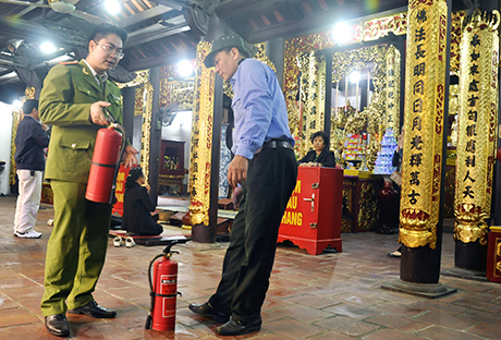 Cảnh sát PCCC tỉnh hướng dẫn bảo vệ ban quản lý đền, chùa nơi diễn ra lễ hội kiểm tra, sử dụng phương tiện PCCC.