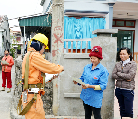 Công nhân Điện lực Vân Đồn phát tờ rơi hướng dẫn sử dụng điện an toàn, tiết kiệm cho người dân xã Quan Lạn (huyện Vân Đồn).
