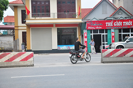Người điều khiển xe máy ngang nhiên đi ngược chiều, không đội mũ bảo hiểm băng qua lối mở trái phép.
