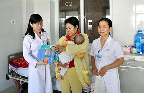 Bác sĩ Đinh Thị Lan Oanh, Khoa Ngoại-Nhi, Bệnh viện Sản-Nhi Quảng Ninh, tặng quà cho mẹ con bé Bàn Trung Thuận đang điều trị tại Khoa.