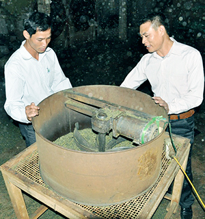Anh Phạm Văn Khiêm (bên phải) giới thiệu về chiếc máy sàng chè.