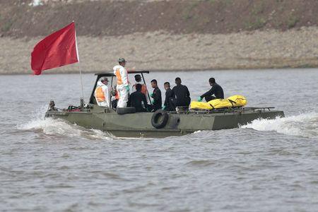 Cứu hộ Trung Quốc vận chuyển các thi thể vào bờ (ảnh: Reuters)