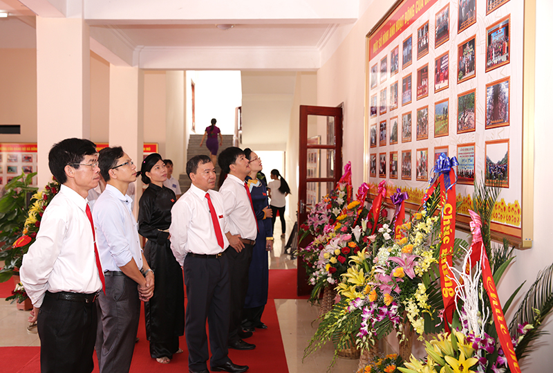 Các đại biểu tham quan khu trưng bày ảnh về thành tựu trong nhiệm kỳ 2010-2015 của Đảng bộ huyện.