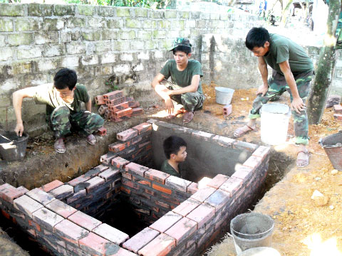 Nhiều hộ dân đã xây dựng nhà vệ sinh đạt chuẩn. Trong ảnh: Cán bộ chiến sĩ Sư đoàn 396, Quân khu 3 hỗ trợ người dân trong xã xây dựng nhà vệ sinh hợp chuẩn.
