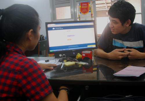 Nhân viên Cơ quan Đại diện Bộ Giáo dục và Đào tạo tại TP HCM hướng dẫn thí sinh đăng nhập vào phần mềm để xem điểm thi THPT quốc gia 2015. Ảnh: Nguyễn Duy.