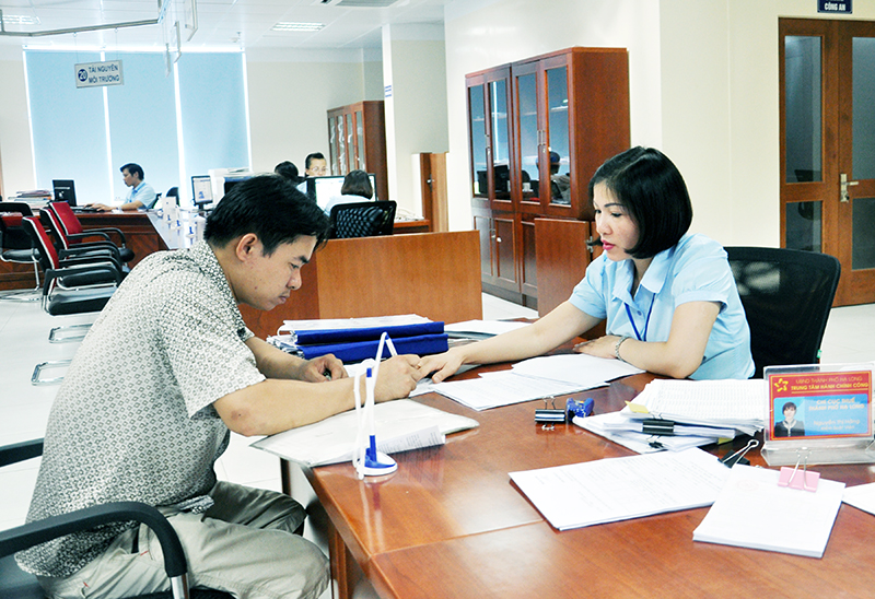 Cán bộ Trung tâm Phục vụ Hành chính công TP Hạ Long hướng dẫn người dân làm hồ sơ tại Trung tâm.