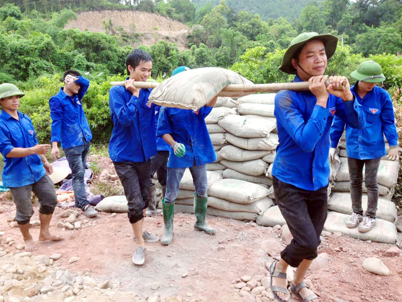 Đoàn viên thanh niên huyện Tiên Yên vận chuyển xi măng làm đường tại thôn Quế Sơn, xã Đông Ngũ (Tiên Yên).
