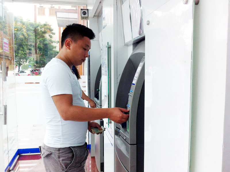 Khách hàng rút tiền tại cây ATM trên đường Lê Thánh Tông (TP Hạ Long).