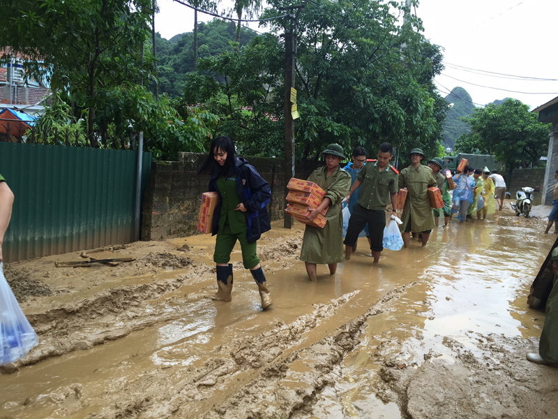 Công an TP Cẩm Phả đưa mỳ tôm đến cho các hộ dân bị ngập sâu trong nước tại phường Quang Hanh.