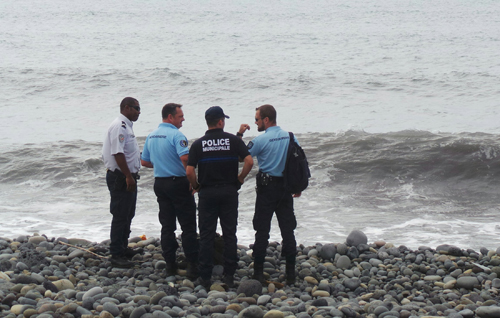 Cảnh sát đứng trên bãi biển ở Saint-Andre, đảo Reunion, nơi phát hiện mảnh vỡ nghi là của máy bay MH370. Ảnh: Reuters