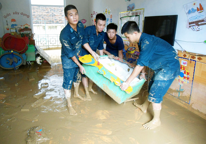 Cán bộ, chiến sĩ Tiểu đoàn 185 (Trung đoàn 213) giúp Trường Mầm non Quang Hanh khắc phục hậu quả mưa lũ.