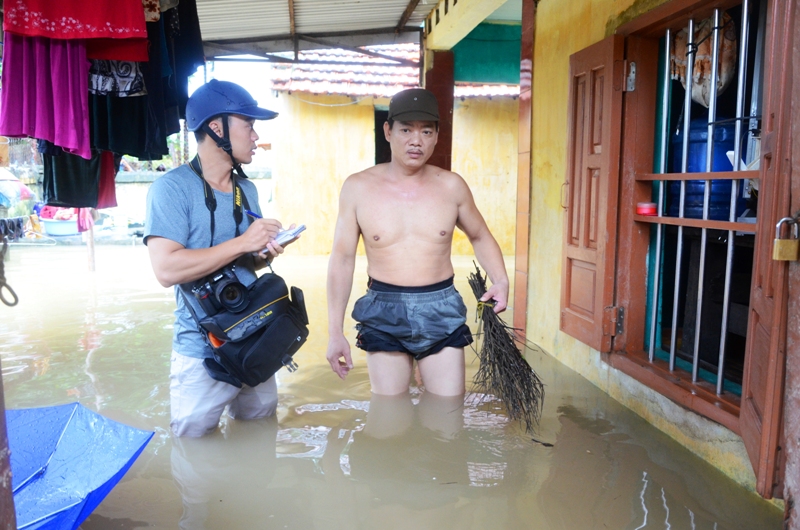  Phóng viên Báo Quảng Ninh đứng trò chuyện với anh Nguyễn Đình Bình tổ 64 khu 7 ( 1 trong những hộ dân bị ngập sâu nhất) vào chiều 3-8 trên hiên nhà mà nước còn ngập tới đùi