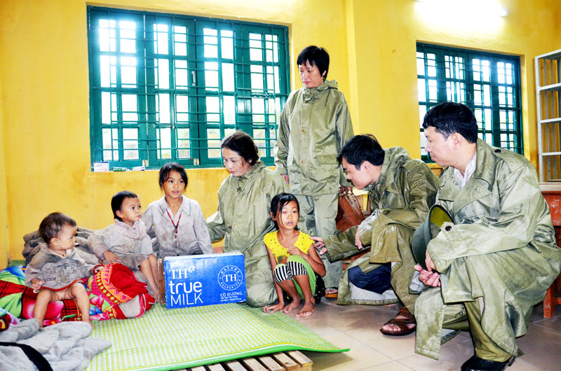 Đồng chí Vũ Liên Oanh, Giám đốc Sở GD-ĐT thăm, tặng quà cho các trẻ em có nhà nguy cơ bị sạt lở, hiện trú tạm tại Điểm trường Khe Vè, Trường Tiểu học Phong Dụ (Tiên Yên), ngày 3-8-2015. Ảnh: Lan Anh