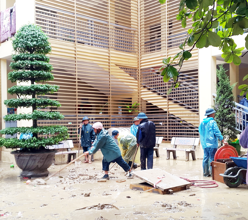 Cán bộ, chiến sĩ Ban CHQS huyện Tiên Yên tham gia thu dọn đất đá sau mưa lụt tại phường Mông Dương (TP Cẩm Phả).