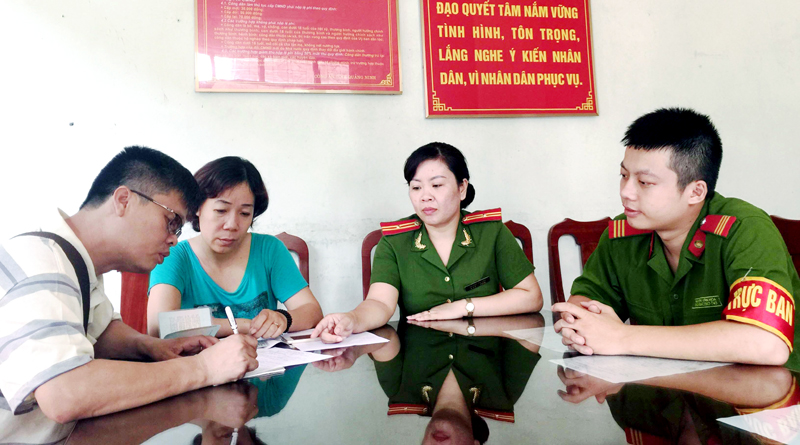 Thiếu tá Hoàng Thị Yến hướng dẫn người dân làm thủ tục hành chính tại trụ sở Công an phường Trần Hưng Đạo, TP Hạ Long.