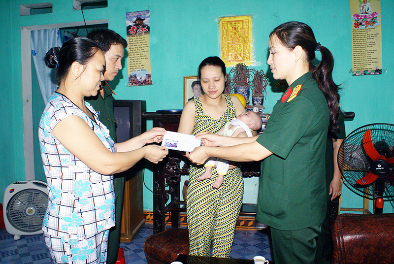 Đại úy Phạm Thị Huế, Chủ tịch Hội Phụ nữ Bộ CHQS tỉnh trao quà giúp đỡ cho gia đình một quân nhân chuyên nghiệp có con mắc bệnh hiểm nghèo.