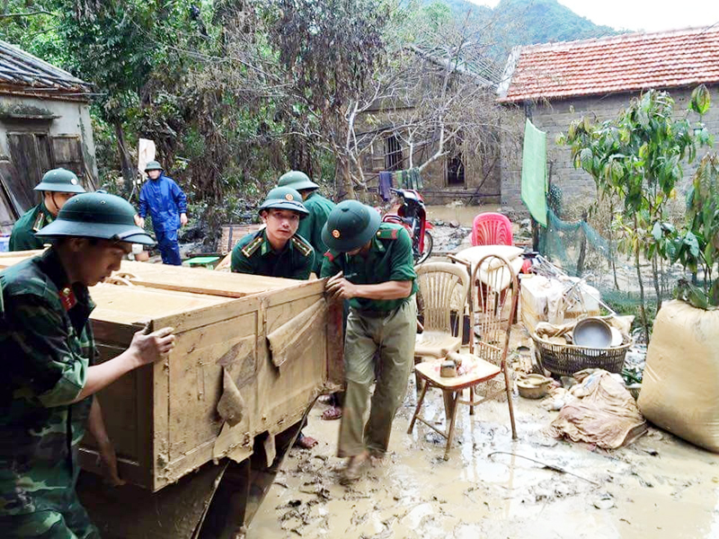 CBCS BĐBP tỉnh giúp nhân dân xã Bản Sen (Vân Đồn) dọn dẹp nhà cửa sau trận mưa lụt cuối tháng 7, đầu tháng 8-2015. Ảnh: Quốc Chiểu (BĐBP tỉnh)