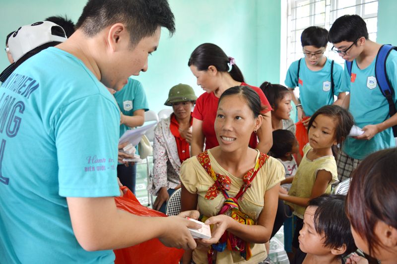 Thầy trò Trường tiểu học, THCS&THPT Đoàn Thị Điểm Hạ Long tham gia phát thuốc và hướng dẫn người dân cách sử dụng. 