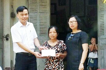Đại diện Công ty CP Xây dựng Thái Dương Hạ Long trao tiền ủng hộ chị Vũ Thị Lâm.