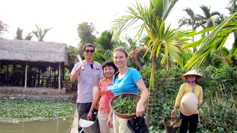 Du khách nước ngoài trải nghiệm làm nông dân tại xã Yên Đức (Đông Triều) một sản phẩm du lịch của Công ty CP Du thuyền Đông Dương. Ảnh: Trần Minh