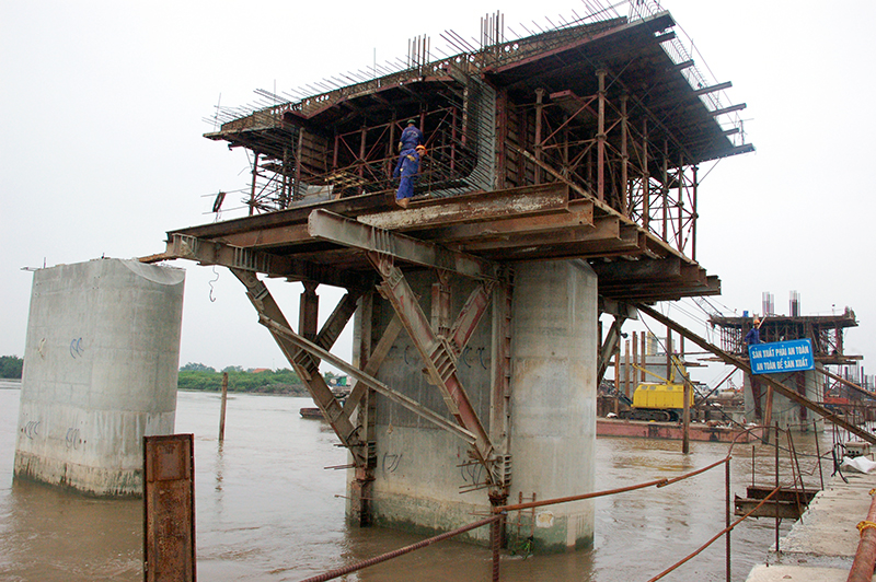 Mới đây nhất, mũi thi công giữa sông (do Công ty Cầu 12 đảm nhận), trong tháng 11-2015 đã thử tải đà giáo khối Ko đầu tiên. Nhà thầu đang tập trung hoàn thiện thi công cốt thép, và ván khuôn trụ để đổ bê tông (ảnh 4). 