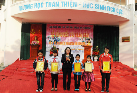 Đồng chí Nguyễn Thị Hiền, Phó Ban chuyên trách Ban ATGT trao giải nhì nội dung tranh vẽ cho các học sinh.