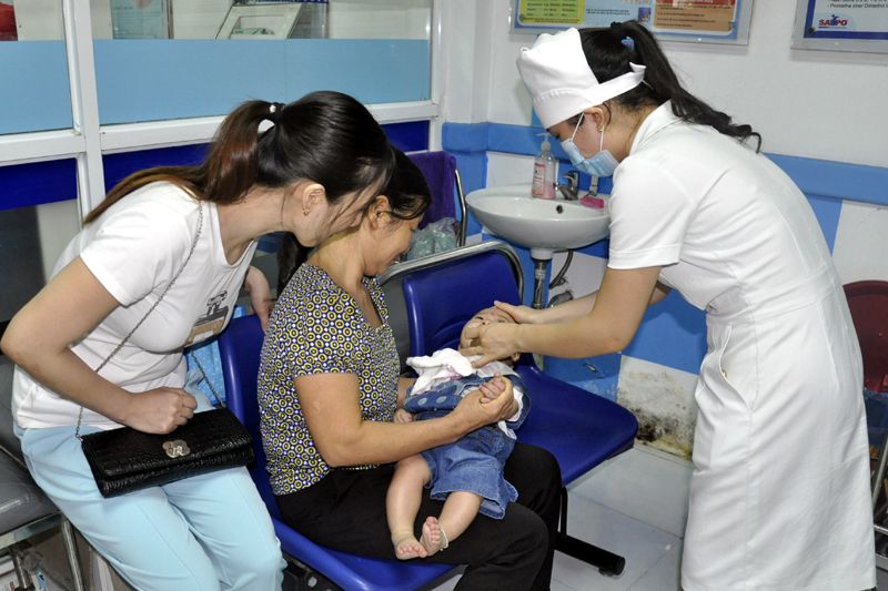 Cho trẻ uống vắc xin phòng bệnh bại liệt tại Trung tâm Y tế dự phòng tỉnh. 