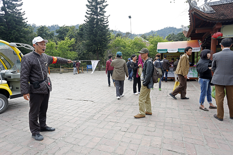 Nhân viên Công ty CP phát triển Tùng Lâm đọc loa hướng dân du khách mua vé xe điện