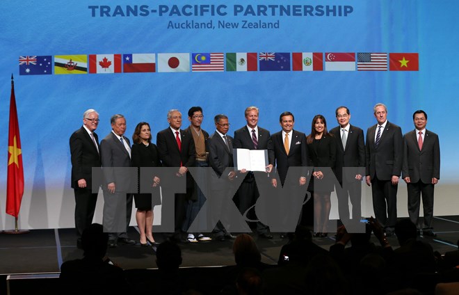  12 Bộ trưởng Thương mại và Kinh tế các nước thành viên tham gia TPP chụp ảnh chung sau khi ký kết văn kiện diễn ra sáng 4/2 ở New Zealand. (Nguồn: AFP/TTXVN)