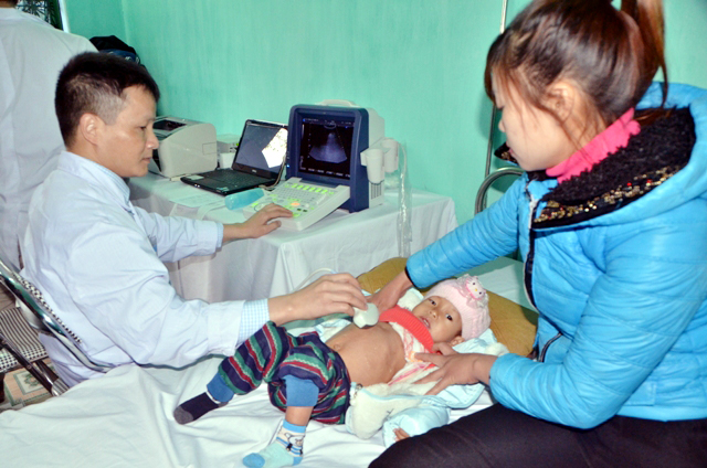 Bác sĩ siêu âm kiểm tra sức khỏe cho một cháu bé ở xã Vĩnh Trung.