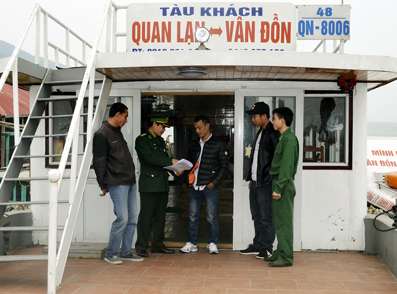 Cán bộ Đội Vận động quần chúng, Đồn Biên phòng Quan Lạn tuyên truyền Luật Bầu cử ĐBQH và đại biểu HĐND cho chủ tàu tại cầu cảng Quan Lạn.