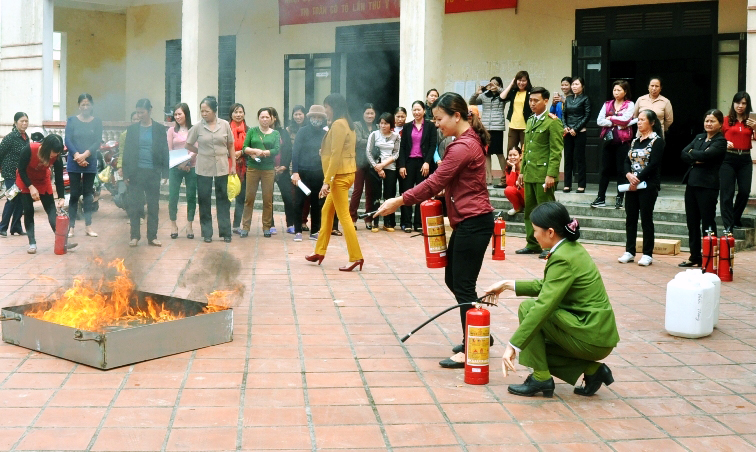 Cán bộ Cảnh sát PCCC hướng dẫn người dân huyện Cô Tô cách sử dụng bình chữa cháy.