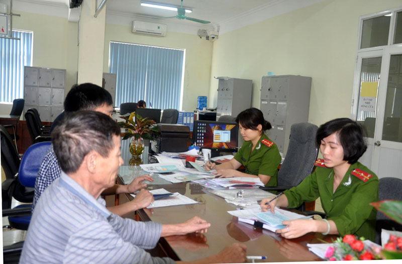 Cán bộ, công chức làm việc tại Trung tâm Hành chính công TP Cẩm Phả hướng dẫn công dân hoàn thiện hồ sơ.