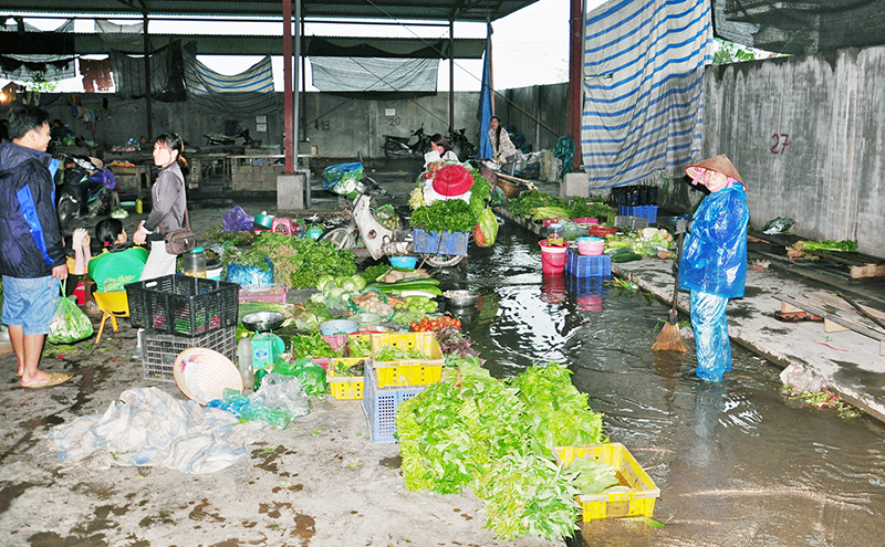 Trời mưa, nước thải chảy tràn qua các sạp rau tại chợ Bang, xã Thống Nhất (Hoành Bồ).