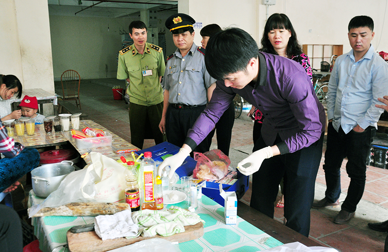 Lực lượng liên ngành lấy mẫu bánh phở và giò tại chợ Bình Liêu (huyện Bình Liêu) làm xét nghiệm nhanh.