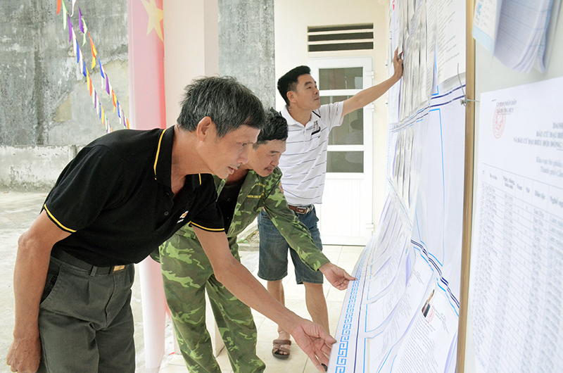 Người dân thôn Tân Tiến, xã Dương Huy tìm hiểu tiểu sử các ứng cử viên ĐBQH và đại biểu HĐND được niêm yết công khai tại nhà văn hoá thôn.