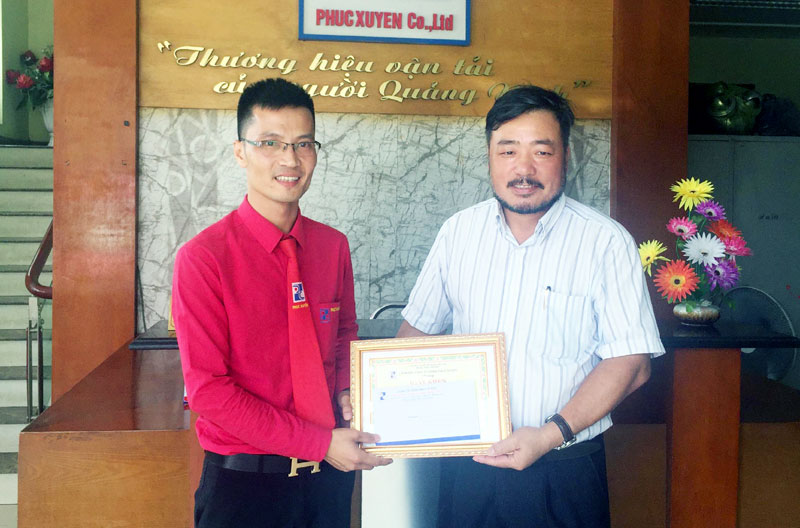 Giám đốc Đoàn Thế Xuyên (bên phải) khen thưởng lái xe Hà Văn Thắng về hành động trả lại tài sản cho hành khách.