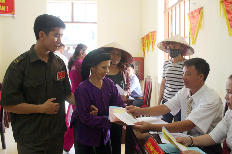 Cử tri tại khu vực bỏ phiếu số 2, xã Hoàng Tân, TX Quảng Yên nhận phiếu bầu cử.