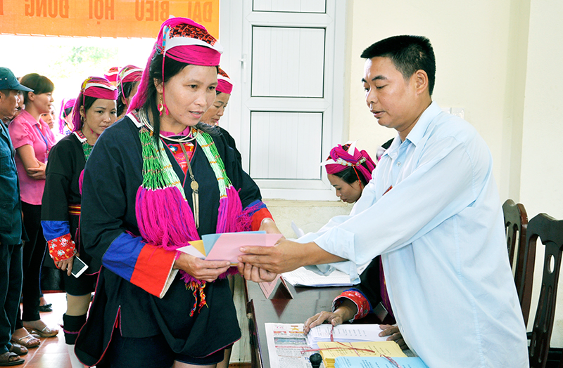 Anh Nịnh Văn Bằng, thành viên tổ bầu cử số 1, thôn Khe Tâm, xã Nam Sơn (Ba Chẽ) hướng dẫn cử tri đồng bào dân tộc Dao Thanh Y làm thủ tục bỏ phiếu.