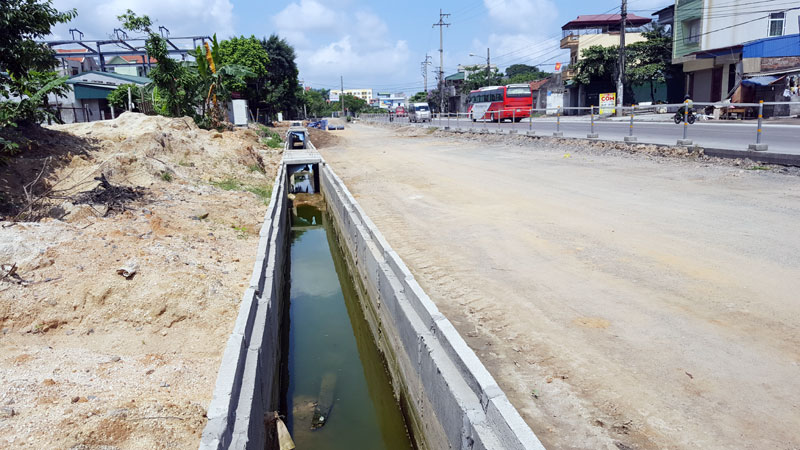 Hệ thống thoát nước dọc tuyến QL18 chưa hoàn thành nên chưa đấu nối với hệ thống thoát nước trong các khu dân cư dẫn tới tình trạng ngập úng cục bộ trong thời gian gần đây. (Ảnh chụp tại đoạn Km5, thuộc phường Cẩm Thạch, TP Cẩm Phả).