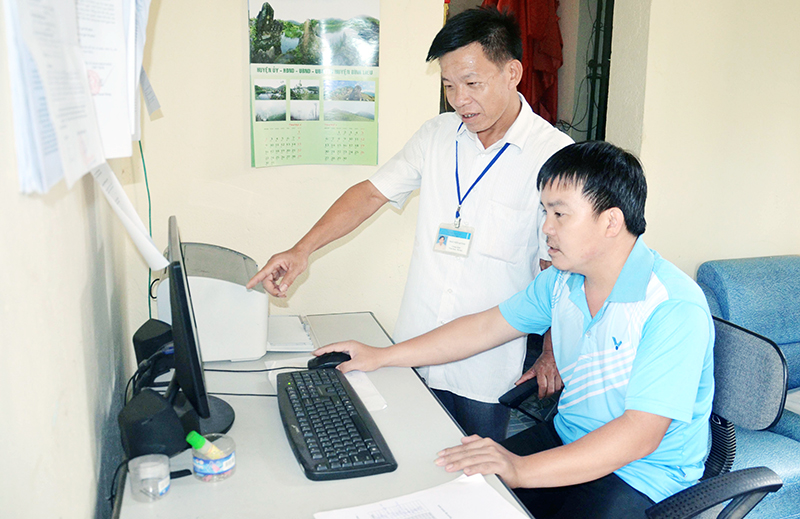 Thầy giáo Nguyễn Ngọc Hải (người ngồi), Trường Tiểu học Tình Húc đang làm việc tại Trung tâm Học tập cộng đồng xã Tình Húc (huyện Bình Liêu).