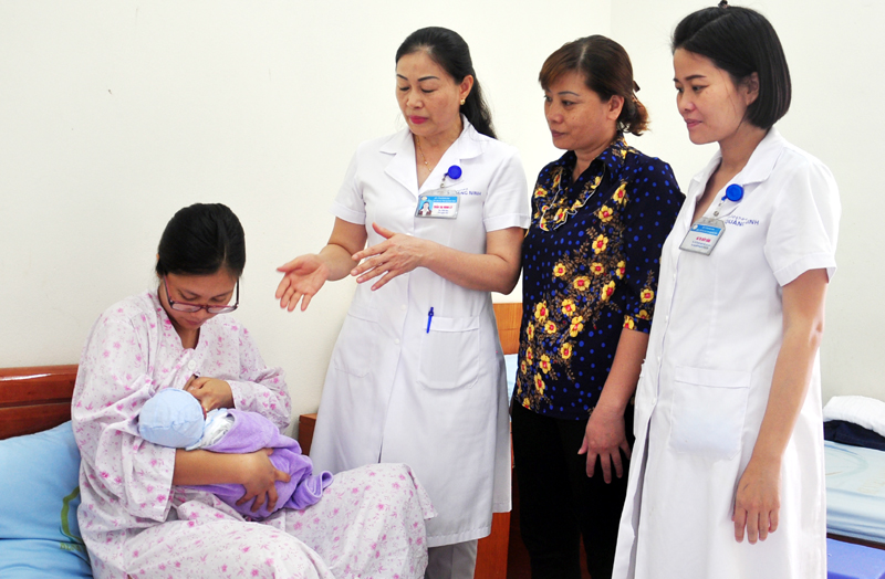 Bác sĩ Trần Thị Minh Lý (thứ ba phải sang) tư vấn cách chăm sóc trẻ sơ sinh cho một sản phụ tại Bệnh viện Sản - Nhi Quảng Ninh.