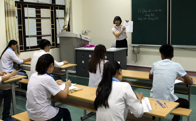 Giams thị hướng dẫn các thí sinh điền thông tin vào tờ giấy thi tại điểm thi Trường THPT Quảng Hà.