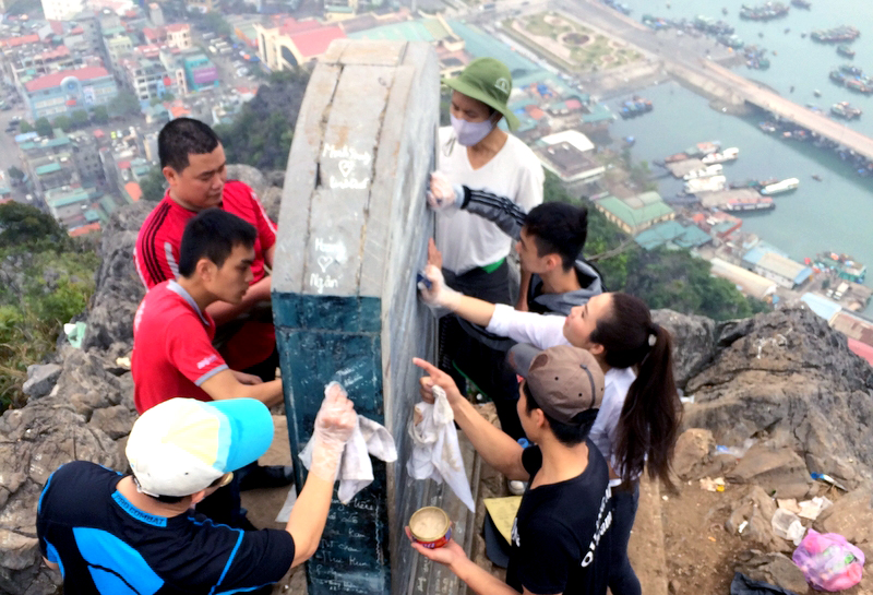 Các bạn trẻ của TP Hạ Long tình nguyện tẩy xoá chữ viết bậy trên bia đá đỉnh núi Bài Thơ.