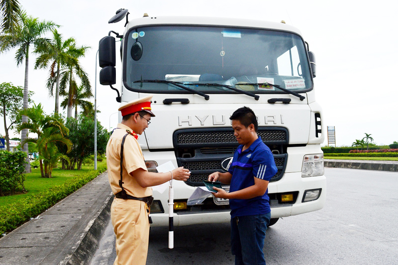 Đội Tuần tra kiểm soát giao thông Trung tâm - dẫn đoàn, Phòng CSGT đường bộ, đường sắt, Công an tỉnh Quảng Ninh kiểm tra phù hiệu của xe tải trên đường quốc lộ.